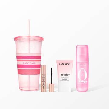 A Lancome beauty set featuring a pink reusable tumbler with a pink striped sleeve, mascara, face cream, and a pink hair and body mist.