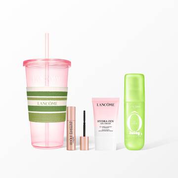 A Lancome beauty set featuring a pink reusable tumbler with a striped sleeve, mascara, face cream, and a green hair and body mist.