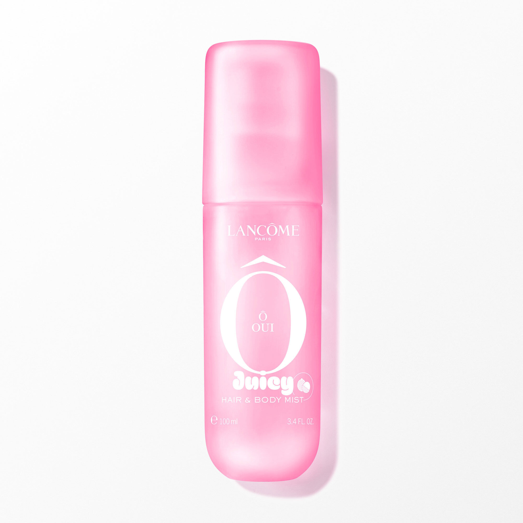 A pink transparent spray bottle with a soft touch finish, containing a clear liquid, with white text on the front. The bottle is positioned vertically in the center, casting a subtle shadow on the white background. The image is brightly lit from the front, with soft, even artificial lighting.
