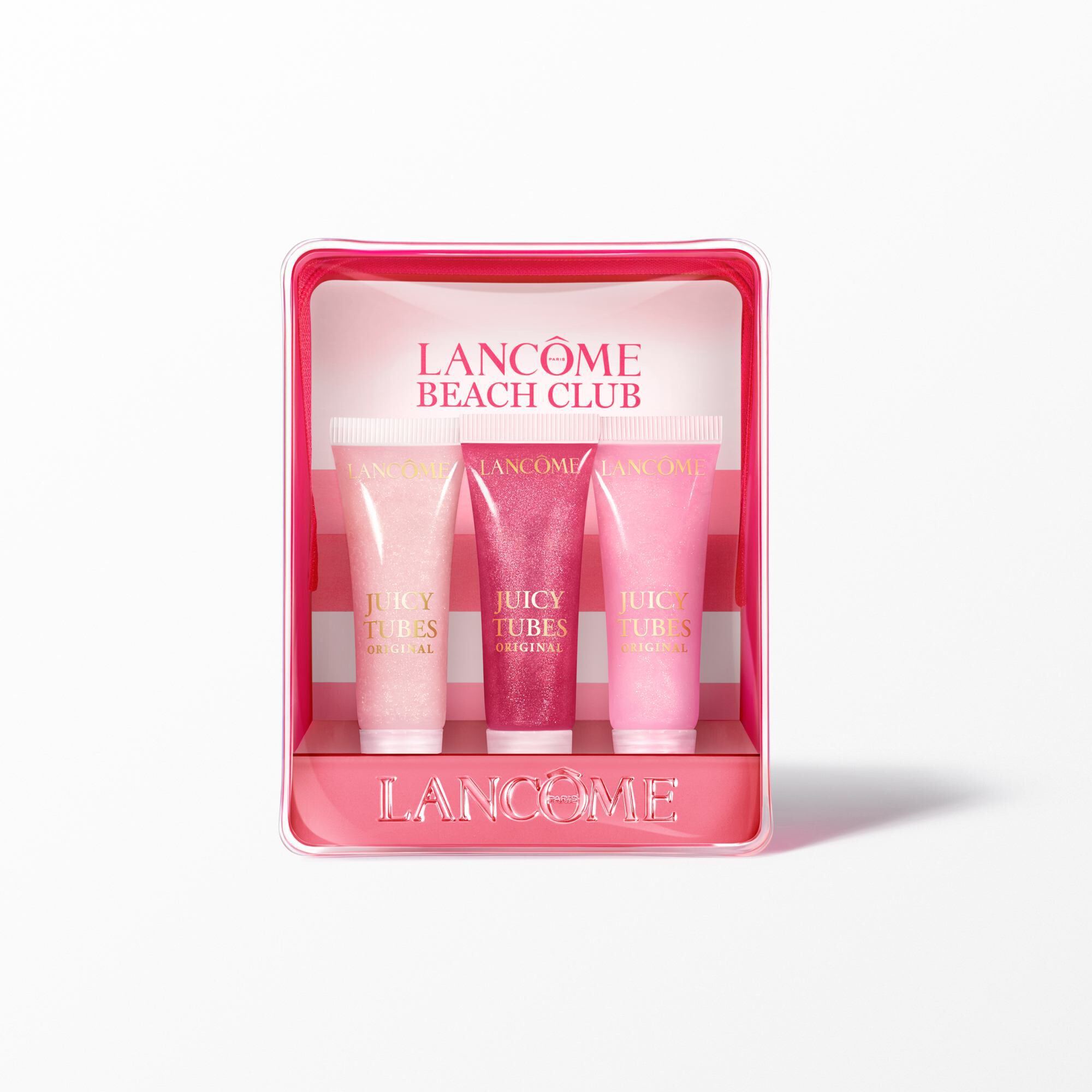 The Lancome lip gloss set with the pink striped pouch standing behind three shades of lip gloss.